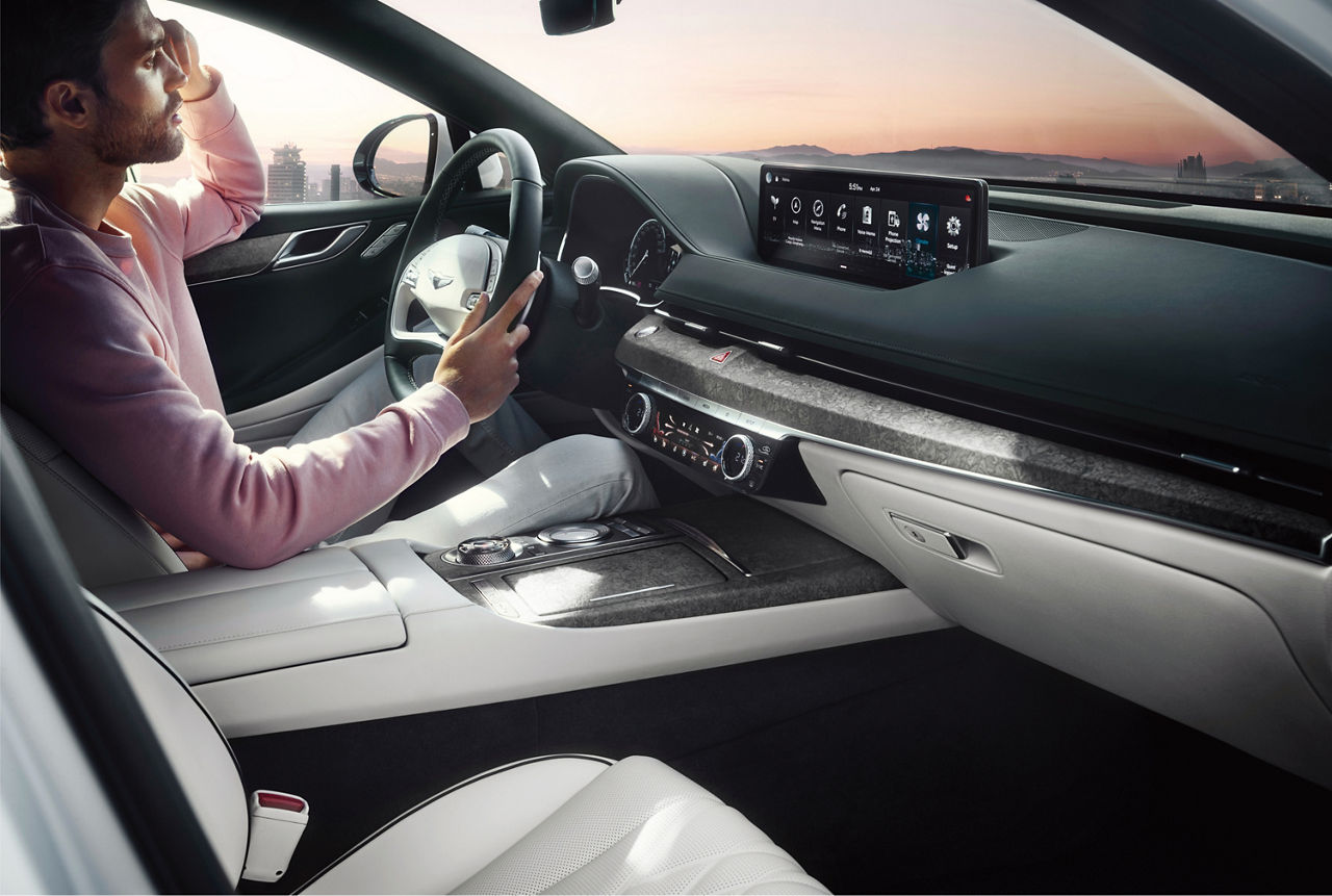 Man at the wheel of the Genesis G80 with beige interior