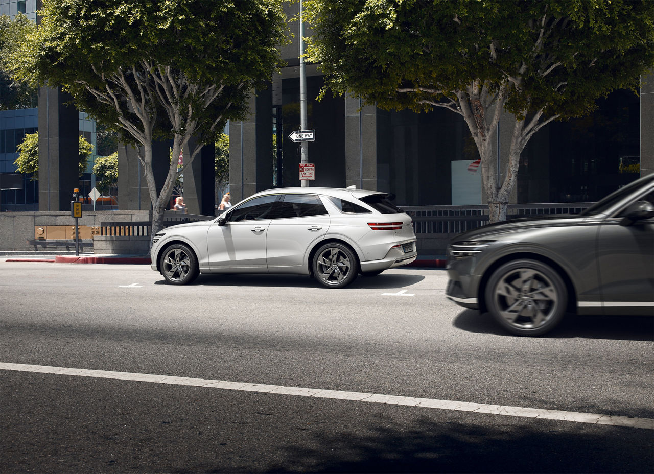 A white Genesis G70 parked on a city street