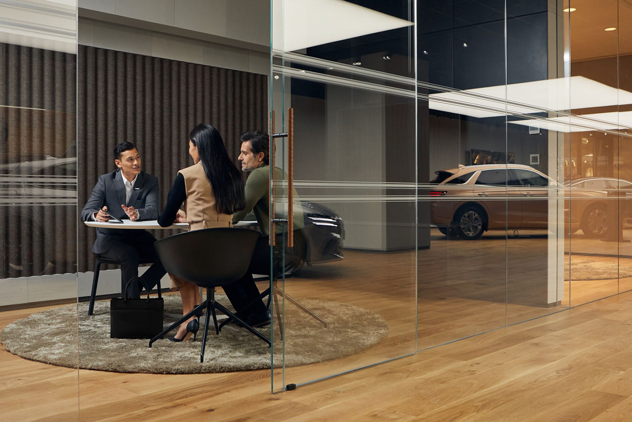 Customer advisor sitting at a table with a man and a woman