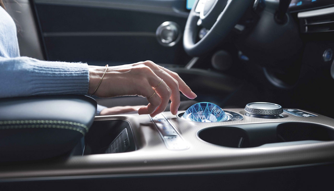 Un bras humain au-dessus de la console centrale d'une voiture