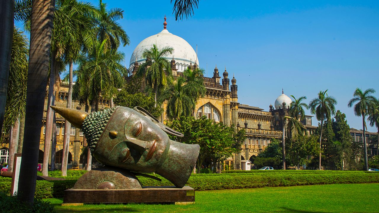 Buddha head carvings on the green grass of the museum. The Prince of Wales Museum (Chhatrapati Shivaji) is located in Mumbai, Maharashtra, India.