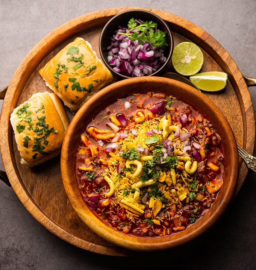 Misal pav is a popular Maharashtrian street food of usal, sprouts curry, topped with onions, tomatoes, farsan and chutney