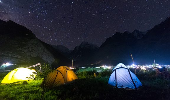 camping tent under milkyway with twinkling stars in the background -