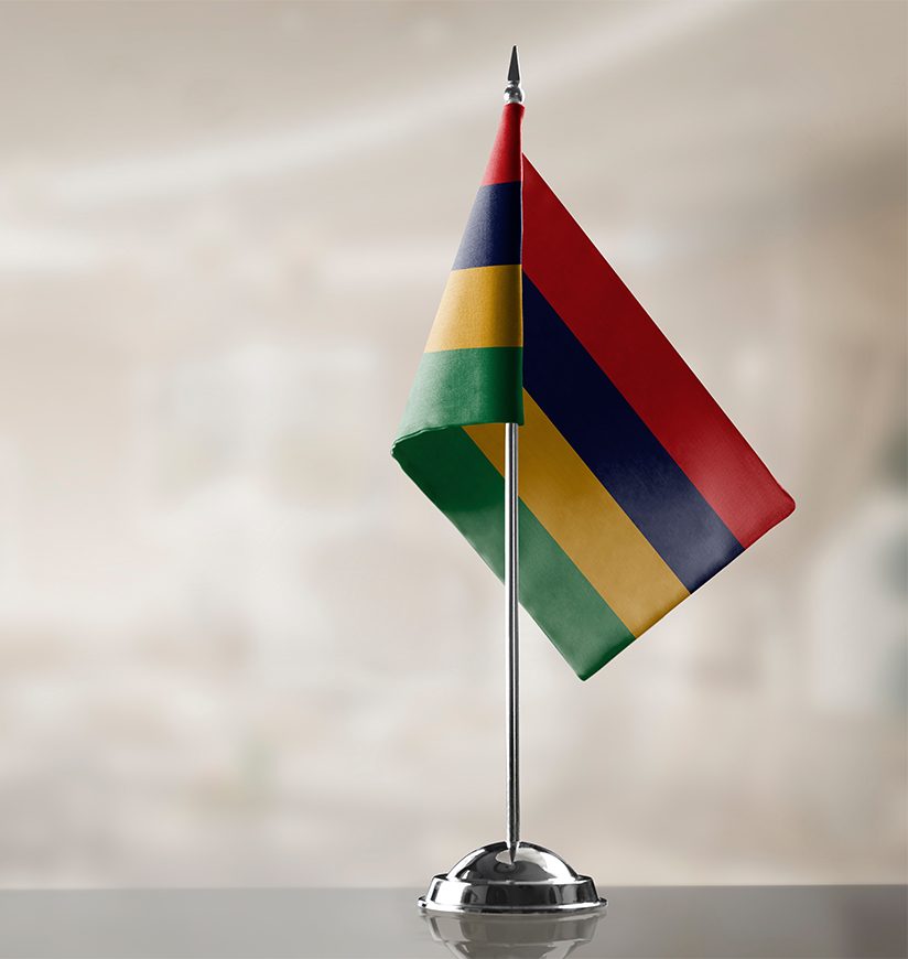 A small Mauritius flag on an abstract blurry background.