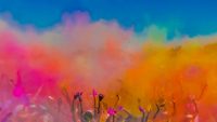 Crowd throwing bright coloured powder paint in the air, Holi Festival Dahan