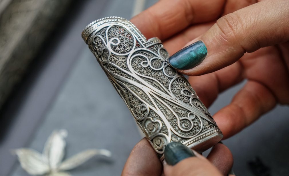 Woman filigree master holds a piece of silver filigree in her hand 