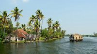 India, Coco trees reflection and beautifoull house boat at back waters of Kerala