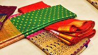 Closeup of Banares silk saris in a textile shop, displayed in front of customers. These exquisite, expensive sarees are famous for their gold and silver zari, brocade. Incredible India.