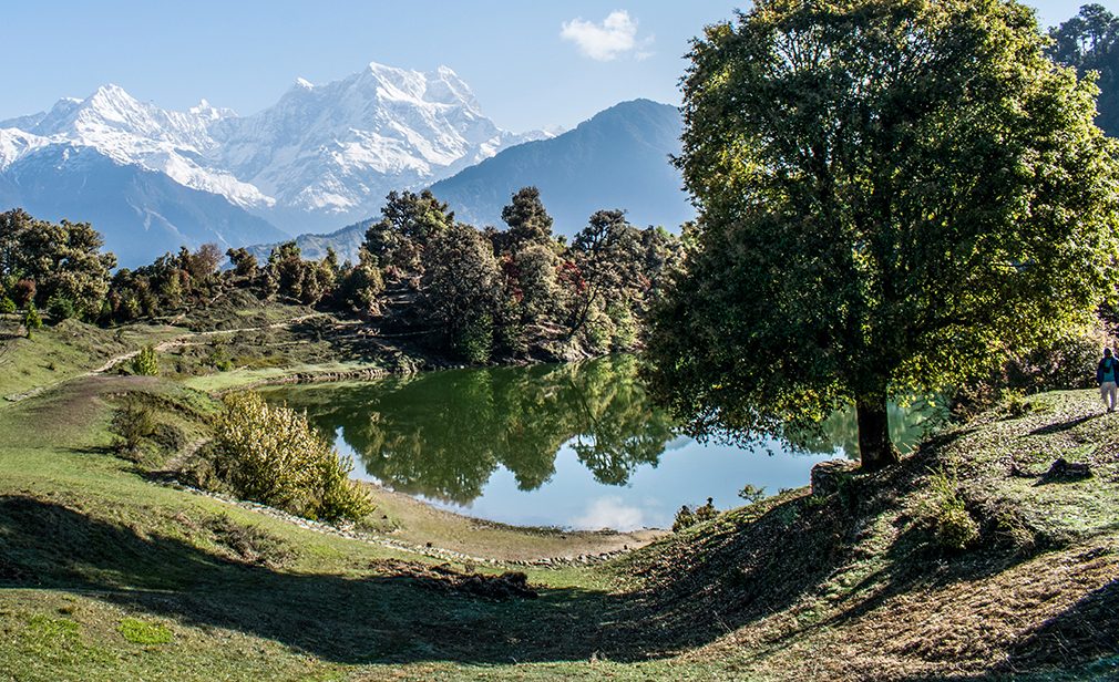 Beautiful bhulla lake having pin drop silence with a forest behind and a hut in the backdrop seen during monsoon trip to lansdowne, uttrakhand, india