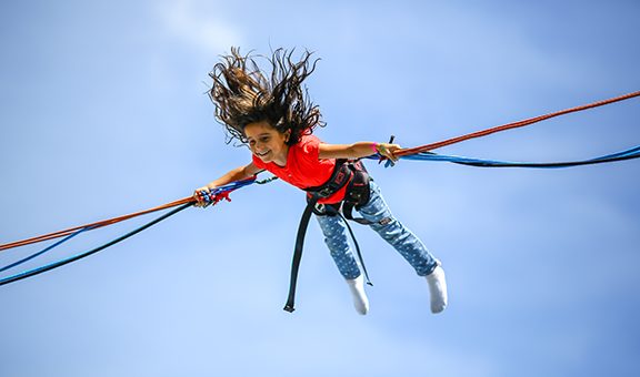 Girl bungee jumping in trampoline