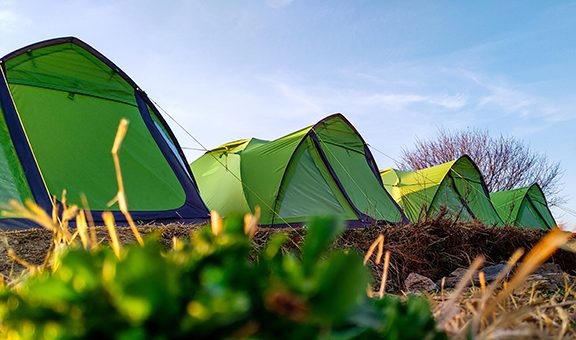 A wide angle shot of a trekking base camp with tents in line.
