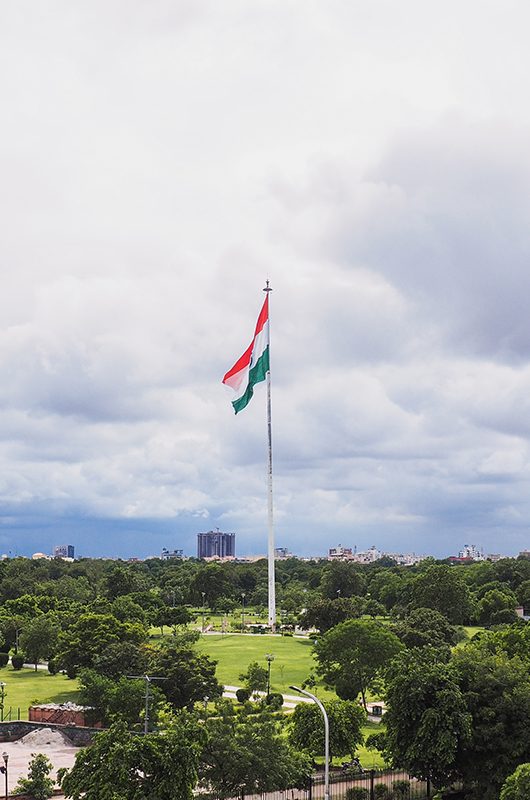 Indian Flag fluttering in the wind under monsoon clouds at Central Park in Jaipur, Rajasthan