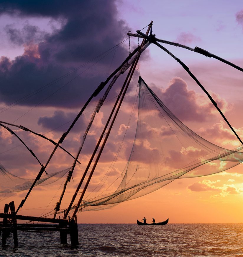 Sunset over Chinese Fishing nets and boat in Cochin (Kochi), Kerala, India.