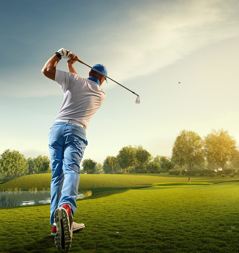 Male golf player on professional golf course. Golfer with golf club taking a shot