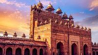 Medieval red sandstone gateway known as the Buland Darwaza at Fatehpur Sikri Agra at sunset with moody sky.