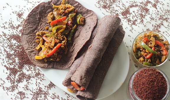 Finger millet Indian flat bread made of finger miller flour. A healthy gluten free alternate to wheat flat bread. Stuffed with stir fried cottage cheese and bell peppers. Shot on white background.