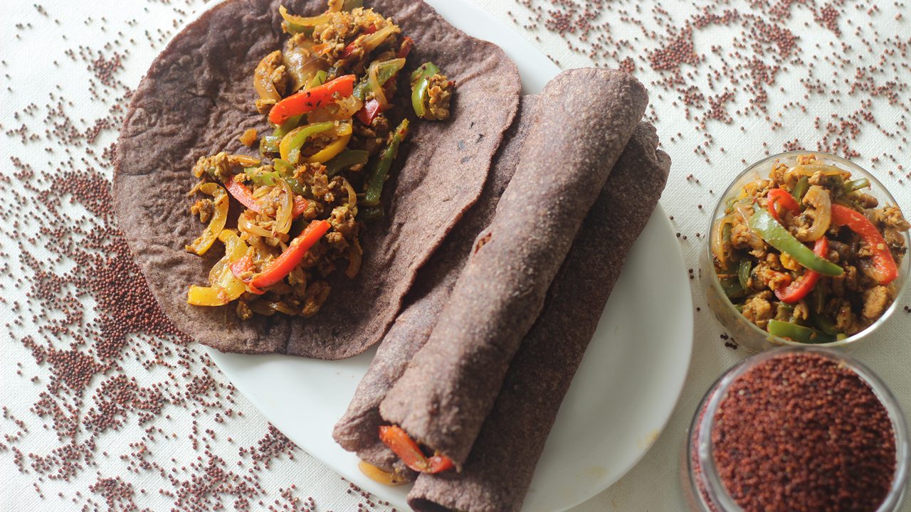 Finger millet Indian flat bread made of finger miller flour. A healthy gluten free alternate to wheat flat bread. Stuffed with stir fried cottage cheese and bell peppers. Shot on white background.