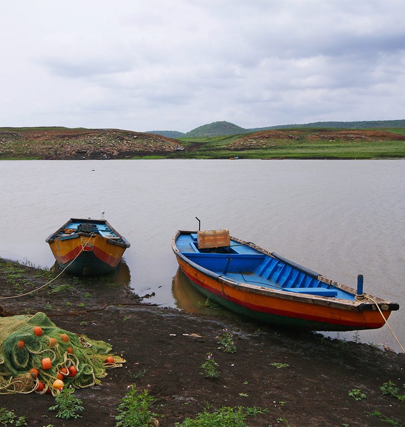 Serene scenic village of India with fishing boats, net and river Krishna