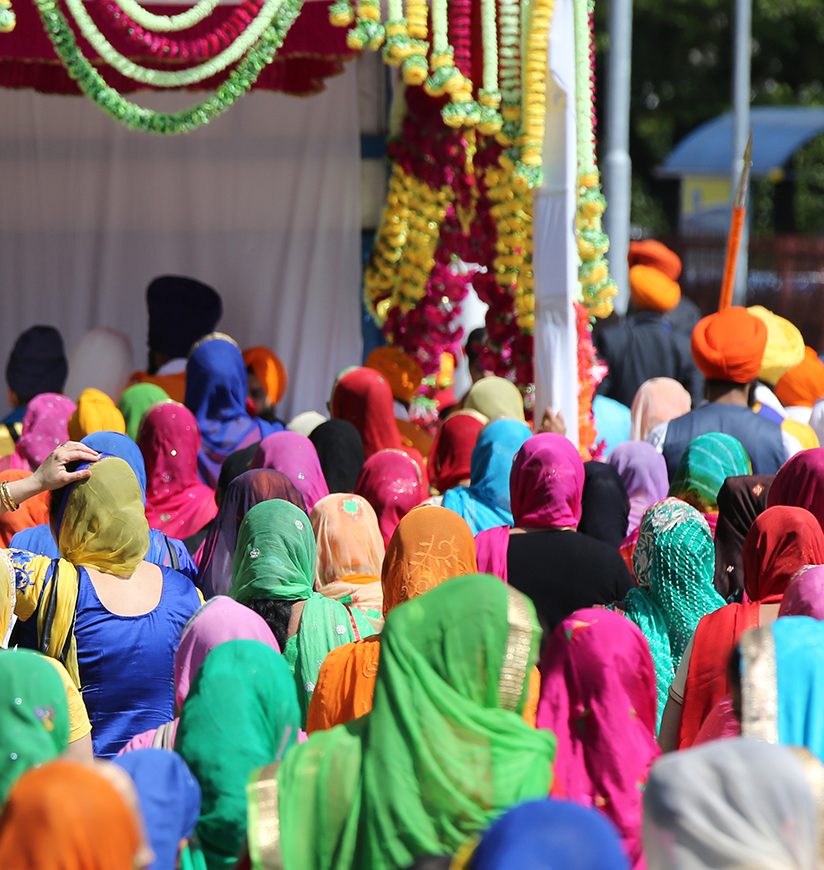 group of people and women with veil in the head during the religious sikh event in the streets of the city