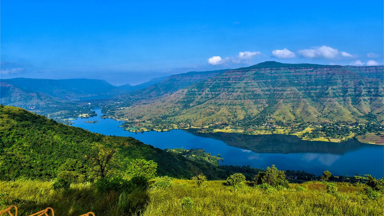 A Beautiful tourist destination, a valley with blue water river / lake, green hill / mountain on backdrop and blue sky. swituated in Panchgani mahabaleshwar, Maharashtra