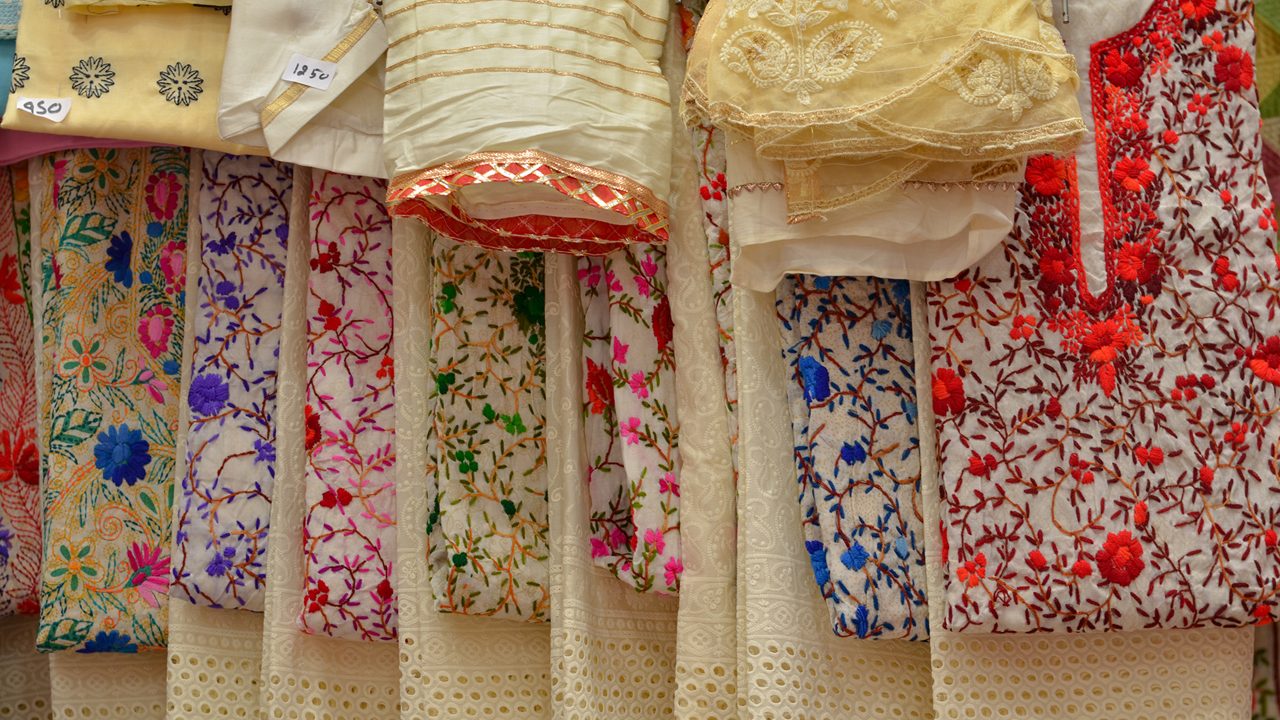 Fancy sarees / unstiched hand woven phulkari chikan embroidery pakistani suits on display in a store Swadeshi khadi handloom exhibition at Dilli Haat, New Delhi, India International Trade Fair (IITF) 