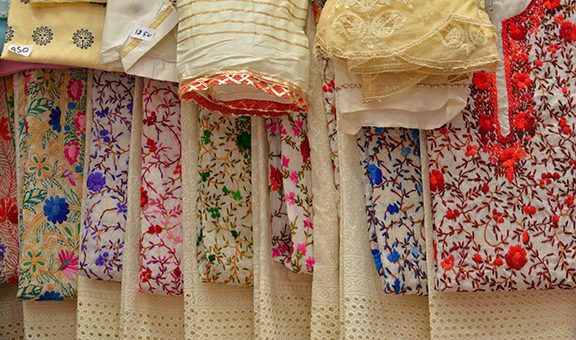 Fancy sarees / unstiched hand woven phulkari chikan embroidery pakistani suits on display in a store Swadeshi khadi handloom exhibition at Dilli Haat, New Delhi, India International Trade Fair (IITF) 