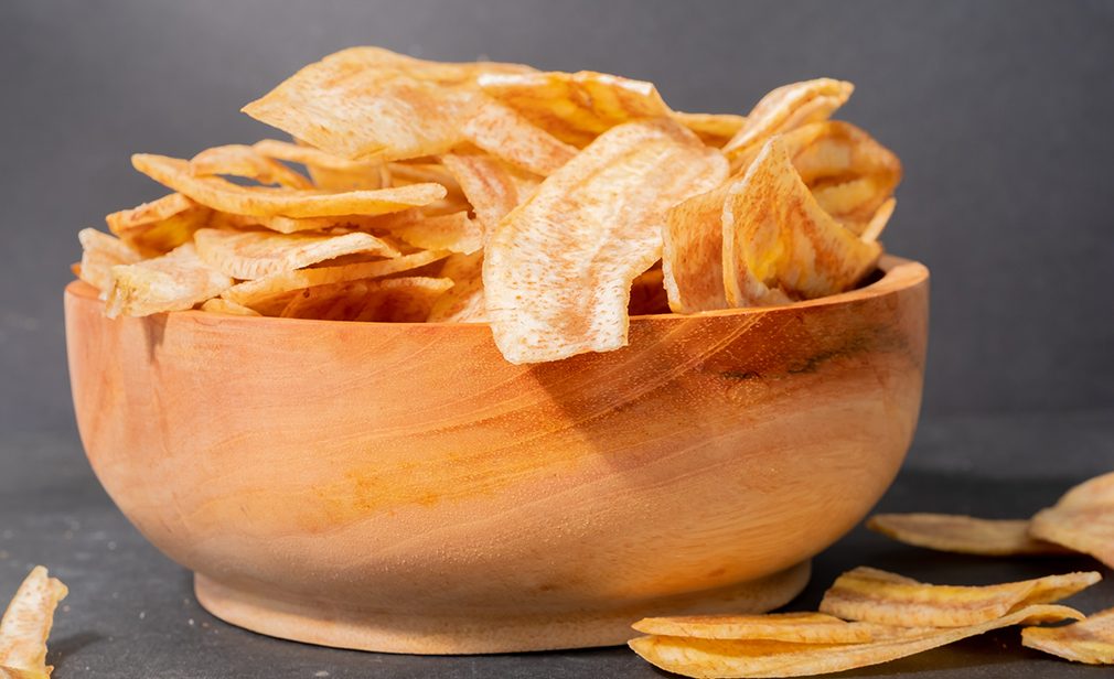 Banana chips with a sweet and salty taste made from fried raw bananas in a wooden bowl. Traditional snacks