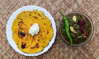 Indian popular dish makki di roti and Sarson da saag, mustard leaves curry and unleavened maize flour bread served in an authentic way with white butter and green chilly.Punjabi traditional style food