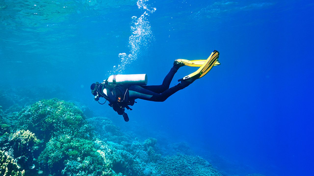 Female scuba diver swimming under water