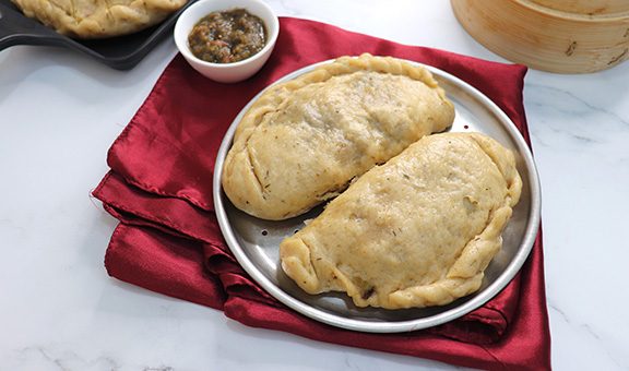 Himachal Pradesh special dish siddu. It's a steamed wheat flour bread stuffed with split black gram lentils, dry fruits, poppy seeds, walnut etc. Served with ghee and tomato chutney. Copy space