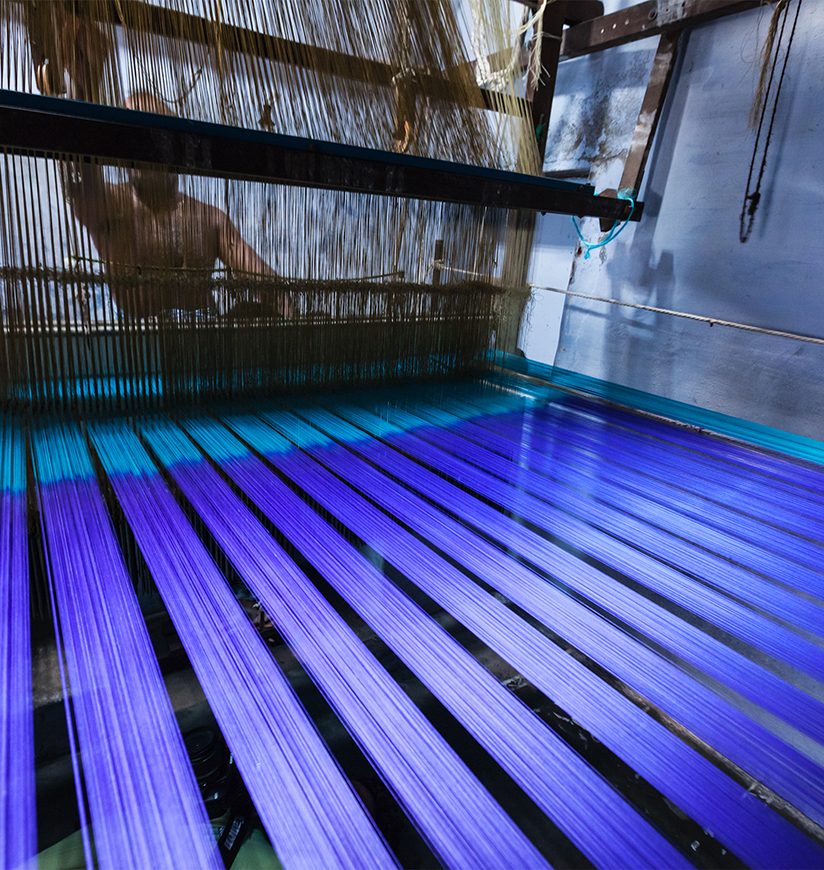 Man weaving silk sari on loom. in Kanchipuram, Tamil Nadu, India. Kanchipuram is famous for hand woven silk sarees and most of the city's workforce is involved in  weaving industry