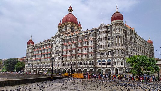 Mumbai, Maharashtra, India - August 11, 2019; The Taj Mahal Palace Hotel is a five-star luxury hotel located near Gateway of India Where lots of tourists are wandering and countless flocks of pigeons are sitting. Resorts & Palaces.