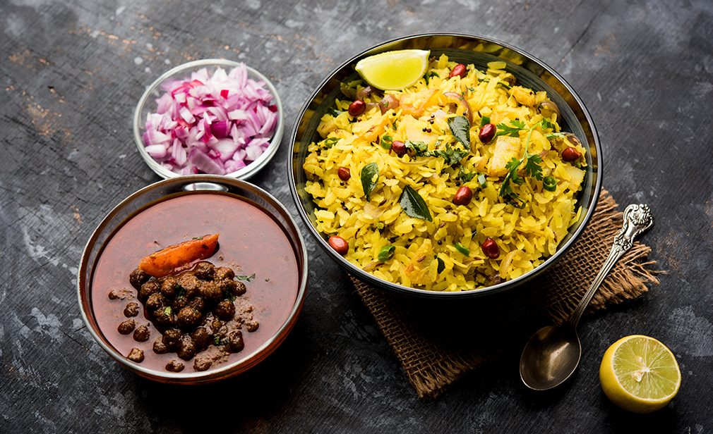 Aloo/Kanda Poha or Tarri Pohe with spicy chana masala/curry. selective focus