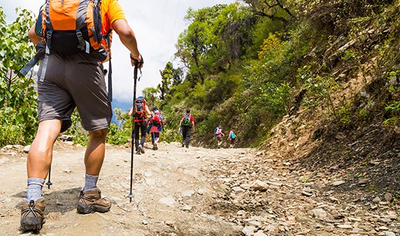 A group of people trekking on dirt road in Nepal