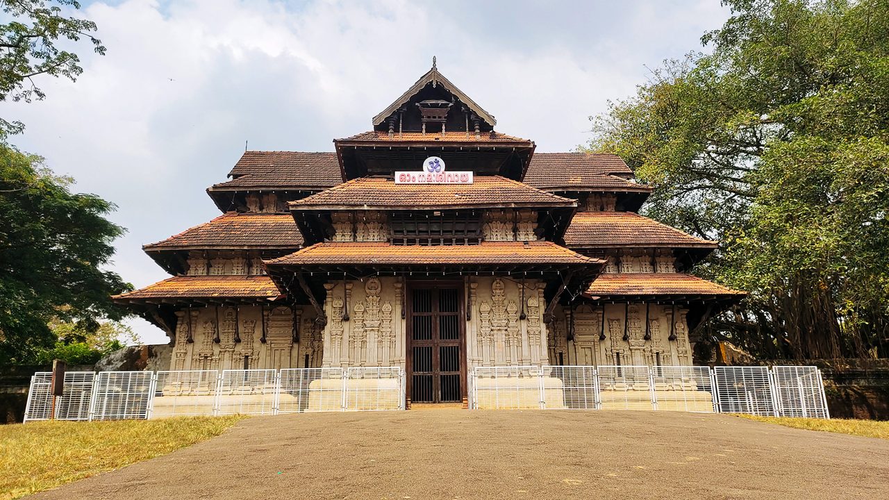 Vadakkumnathan or lord shiva ancient old traditional style south indian hindu religion stone temple building in kerala, thrissur. Front view with Om Namah Shivaya Mantra text in Malayalam language.