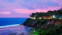 Kerala, India. Varkala beach at night, various cafes and restaurants at the cliff with colorful sunset sky and motion blurred Laccadive Sea and Papanasam beach in Kerala, India