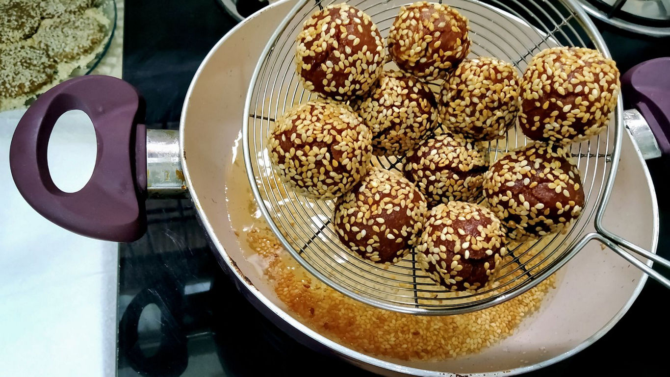Sesame coated fried snack balls in pan