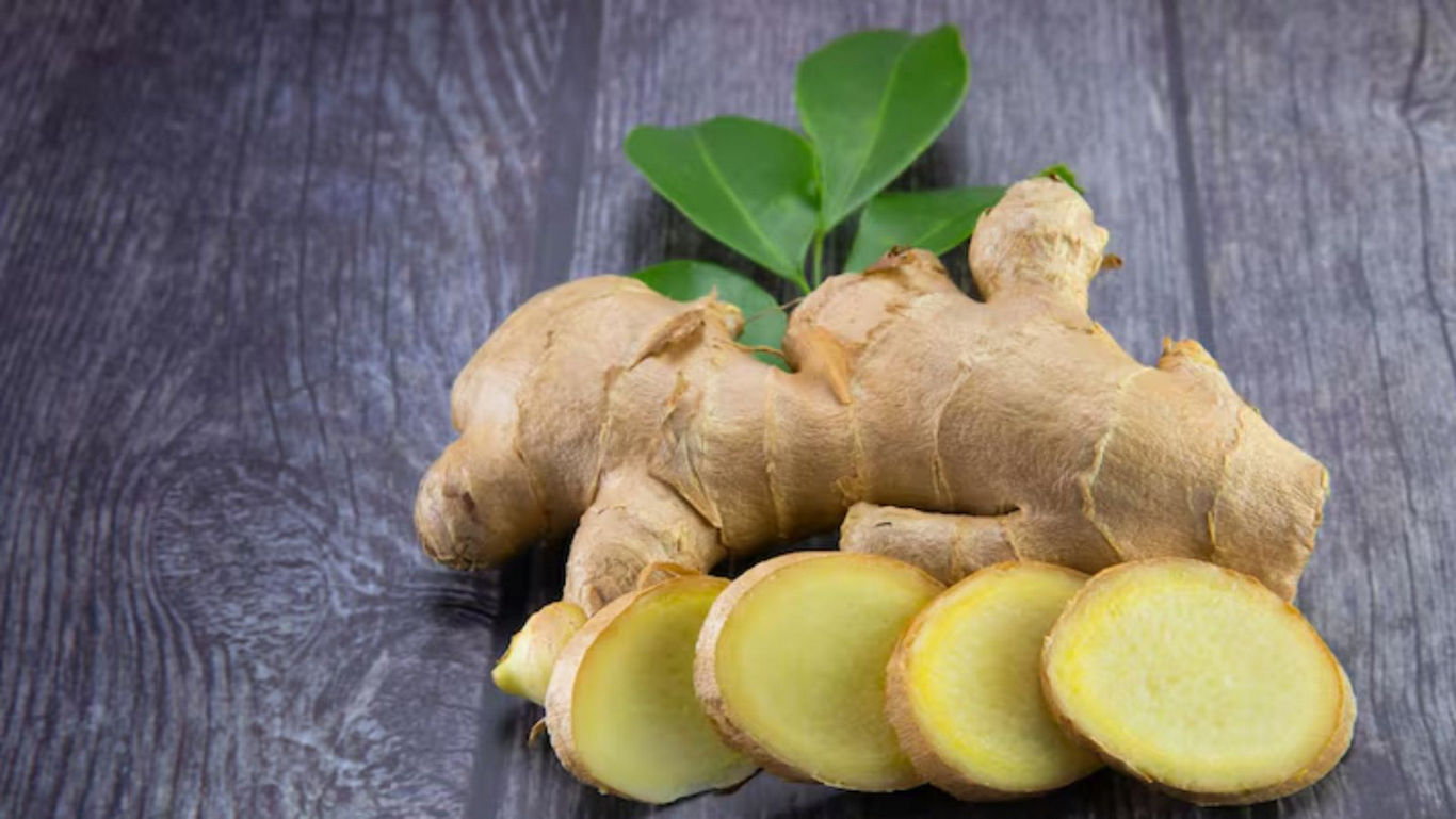 Fresh Ginger Root with Slices on Wooden Surface
