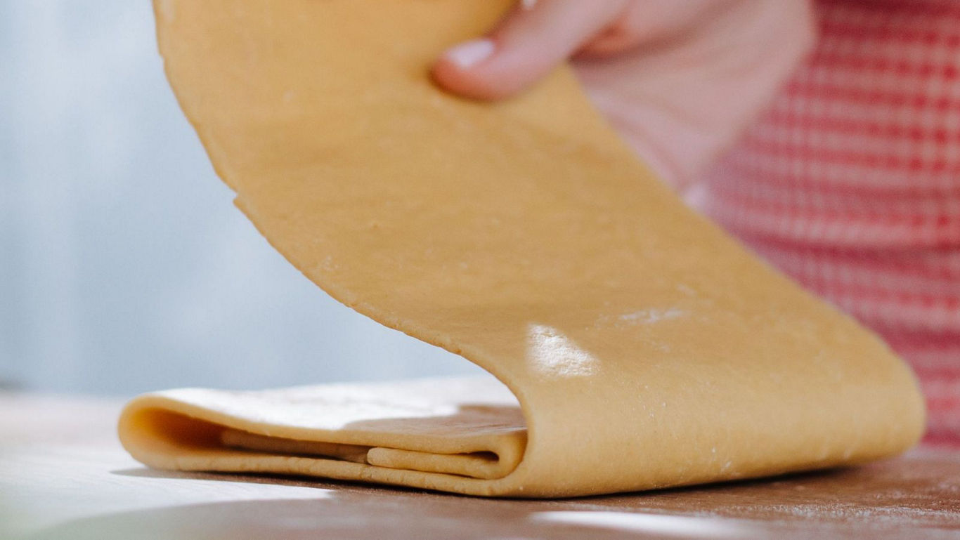 Close-up of dough being folded on table