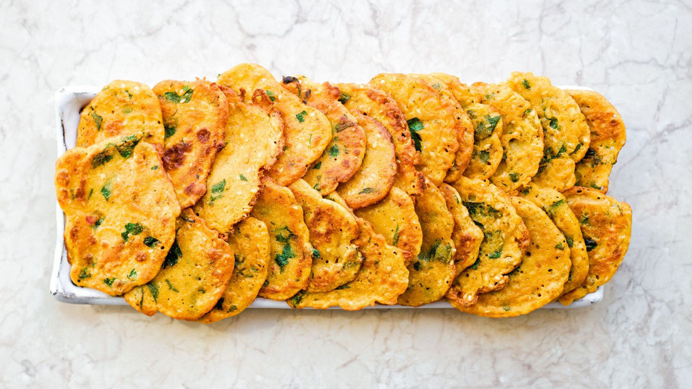 Golden savory pancakes on marble tray