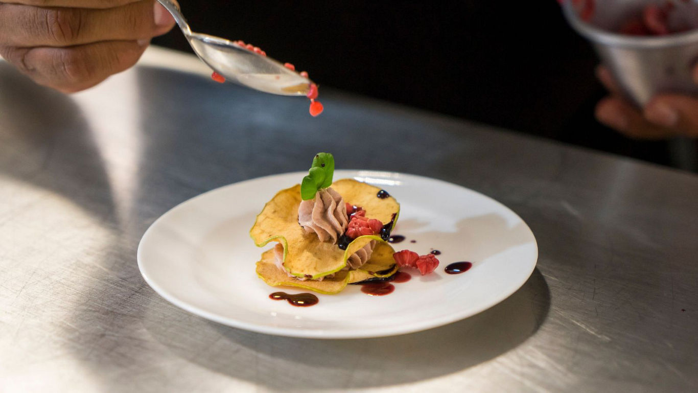 Chef plating gourmet dessert with garnish