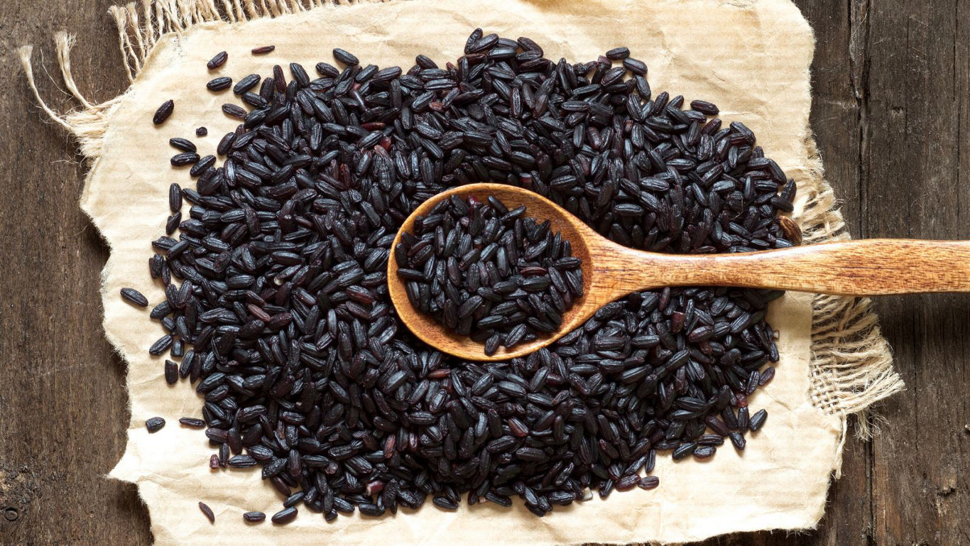 Wooden spoon filled with black rice