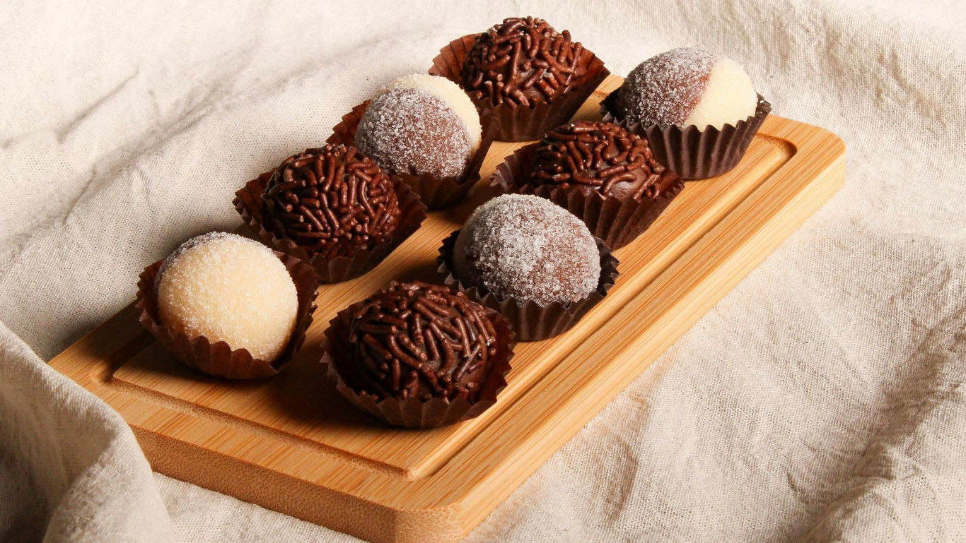 Assorted chocolate truffles on wooden board