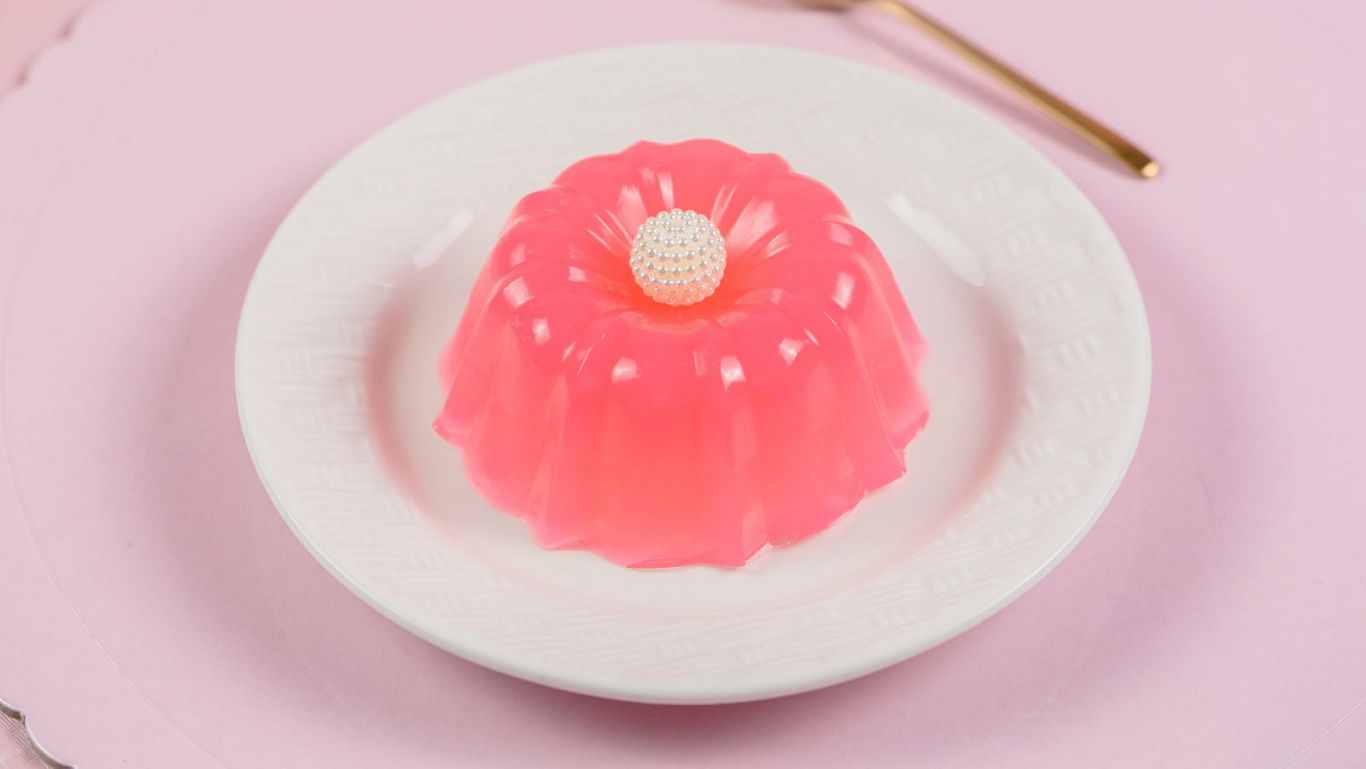 Pink gelatin dessert on white plate