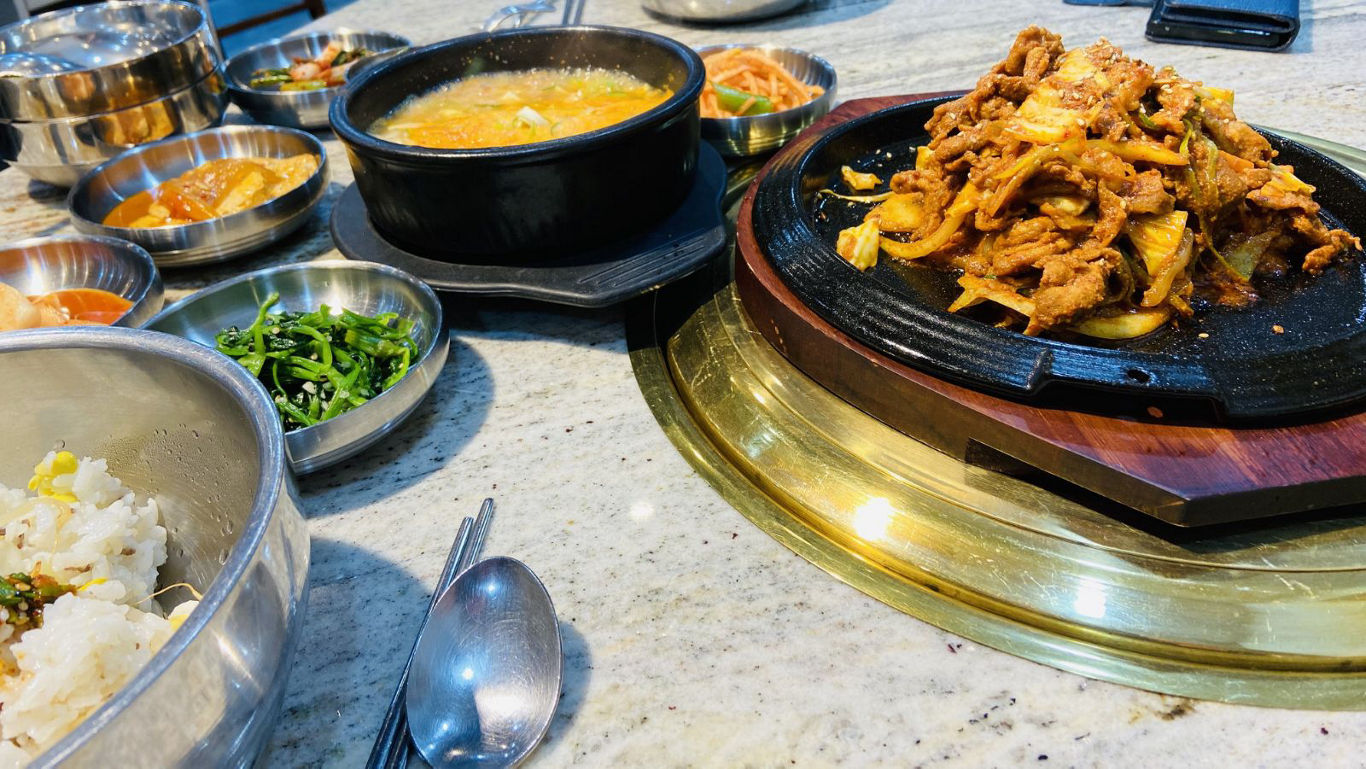 Korean Barbecue Meal with Side Dishes on Table