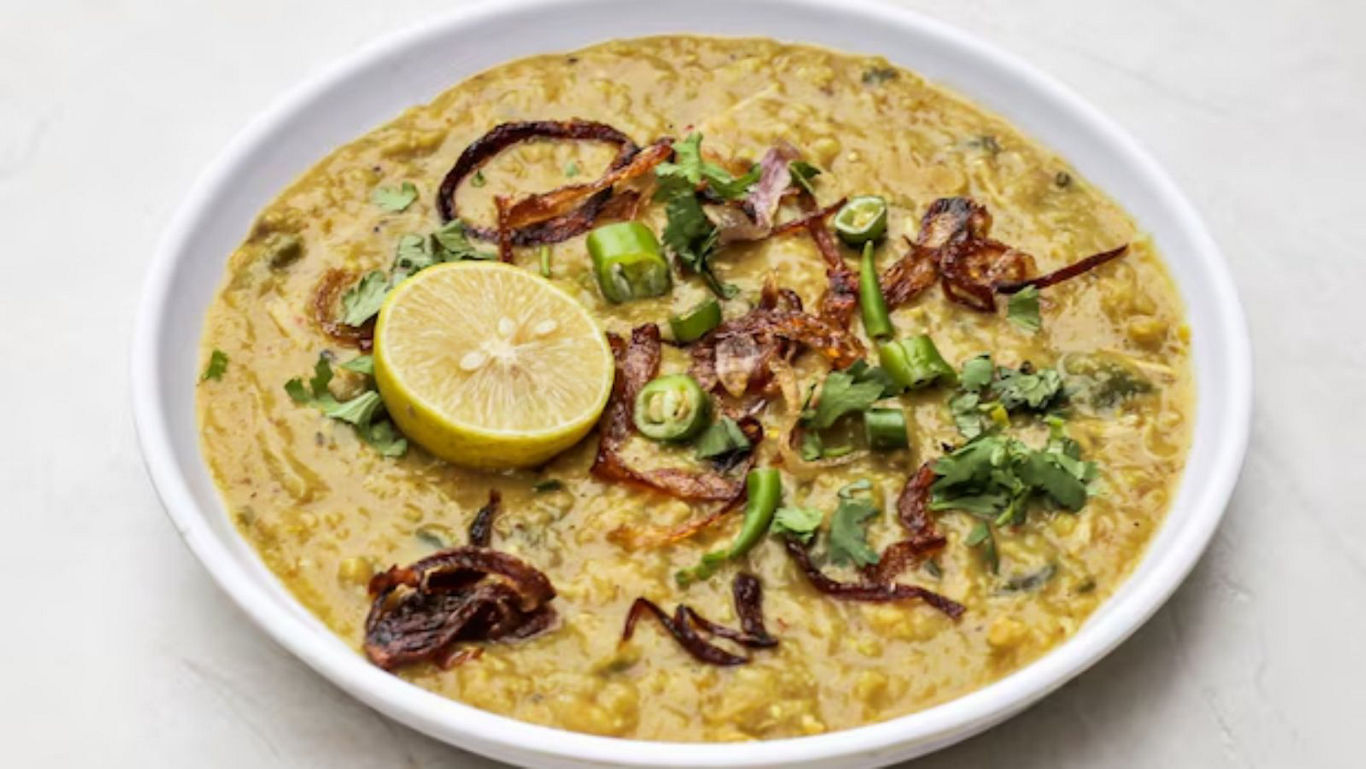 Bowl of Indian dal garnished with lemon and herbs
