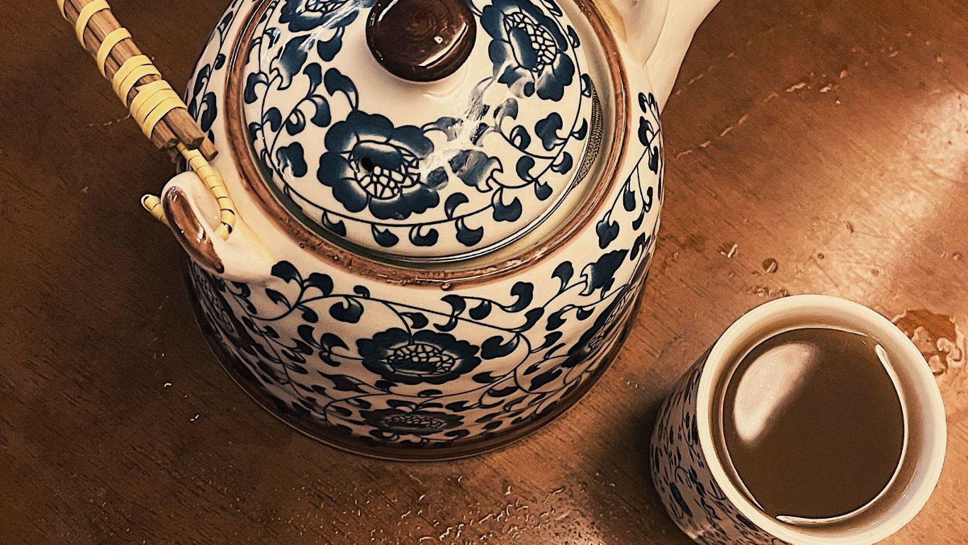 Ornate porcelain teapot with matching teacup