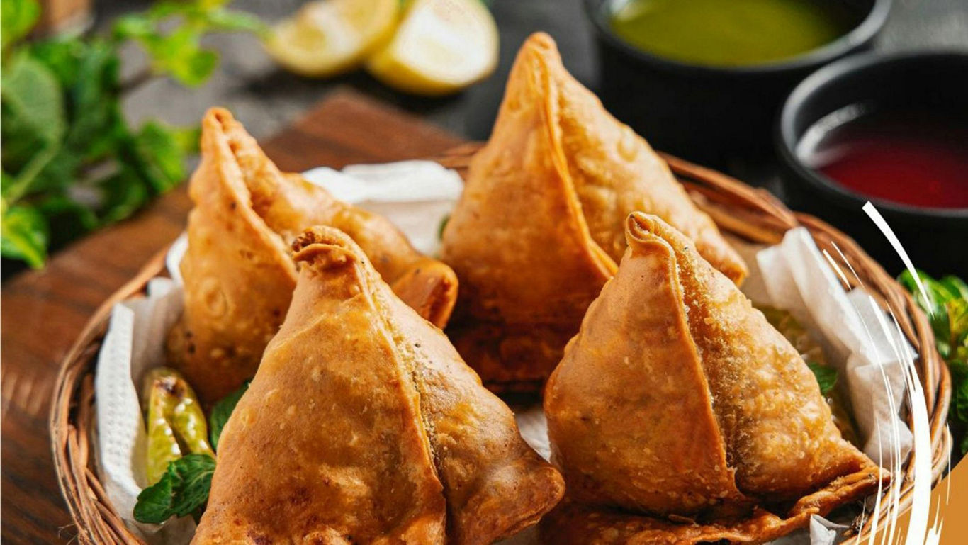 Crispy fried samosas in wicker basket