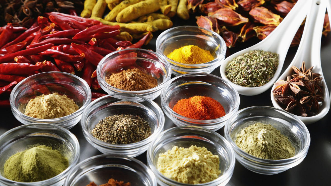 Assorted spices in glass bowls and spoons