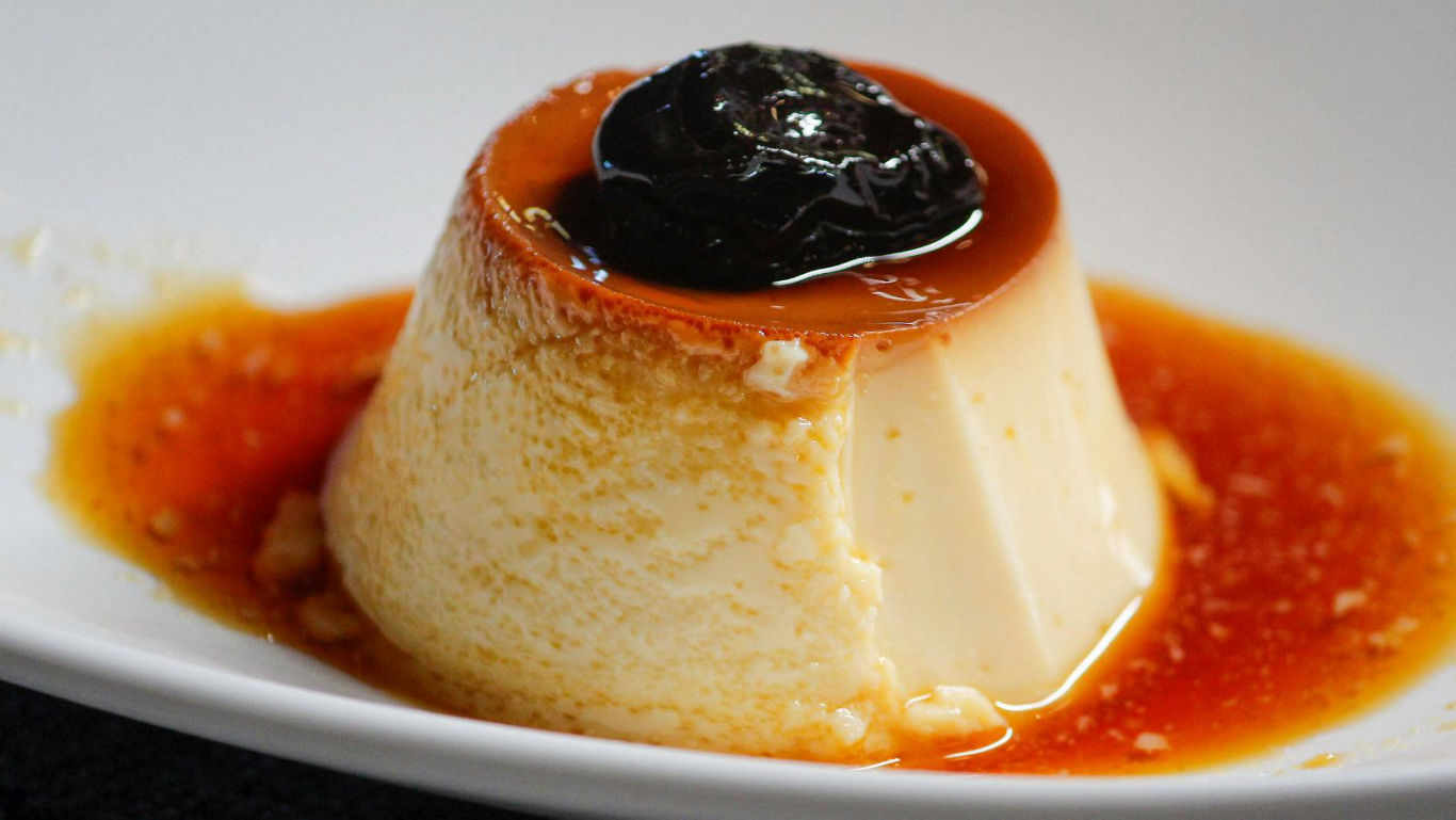 Caramel flan dessert with dark fruit topping
